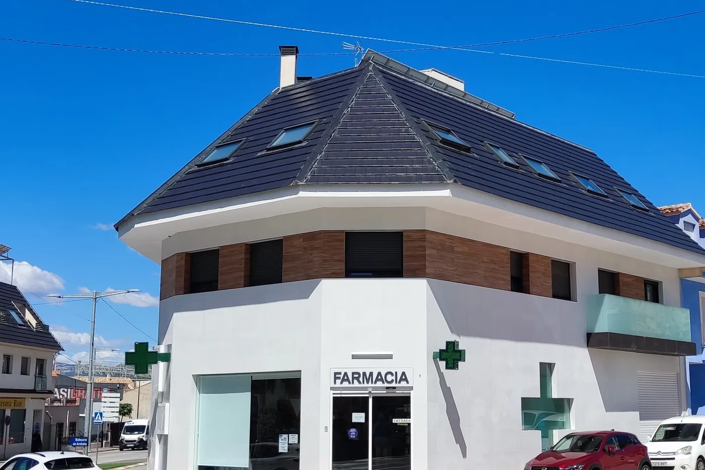 Fachada de la Farmacia La Salud en la calle Viena de Archena, con la cruz verde iluminada